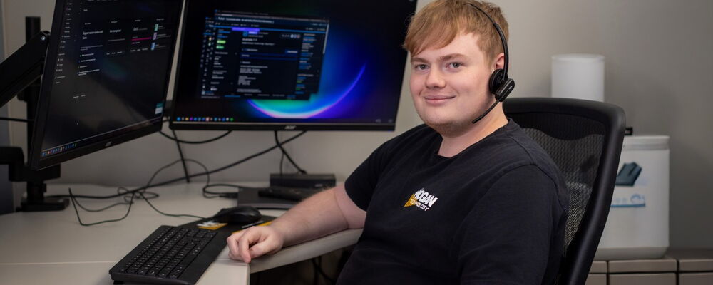 Man Sitting at Computer Desk with Earpiece
