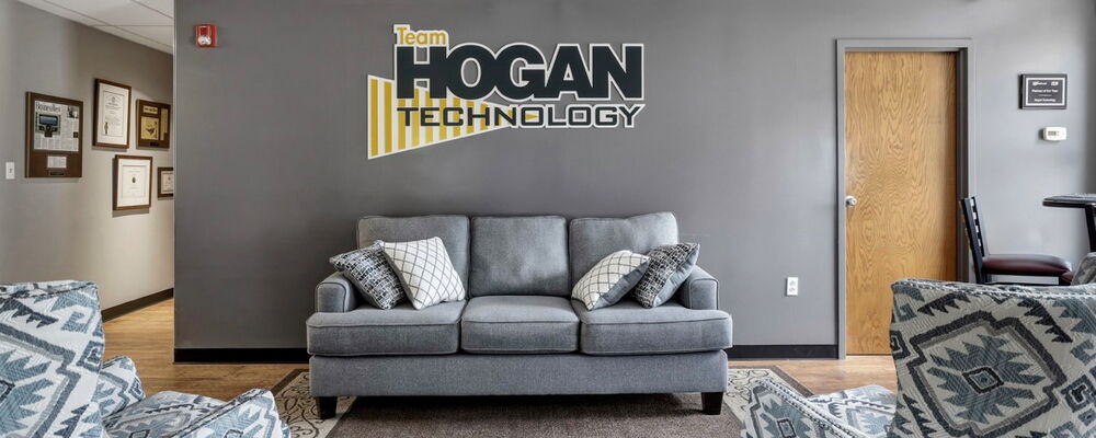 Couch beneath Team Hogan Technology sign