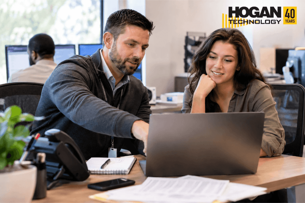 Employees collaborating on technology solutions in a modern office environment.
